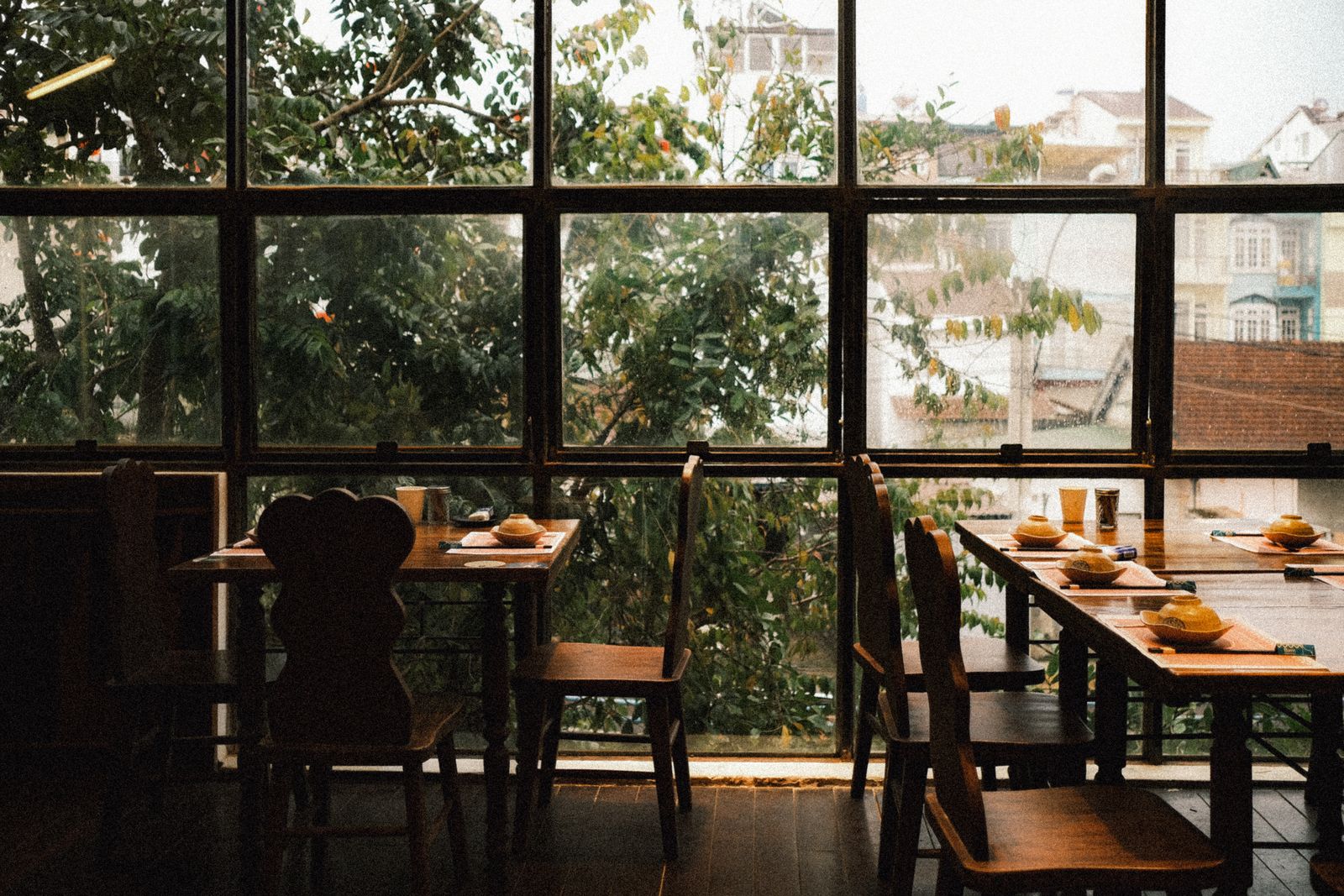 Dining room with wooden tables by tall windows